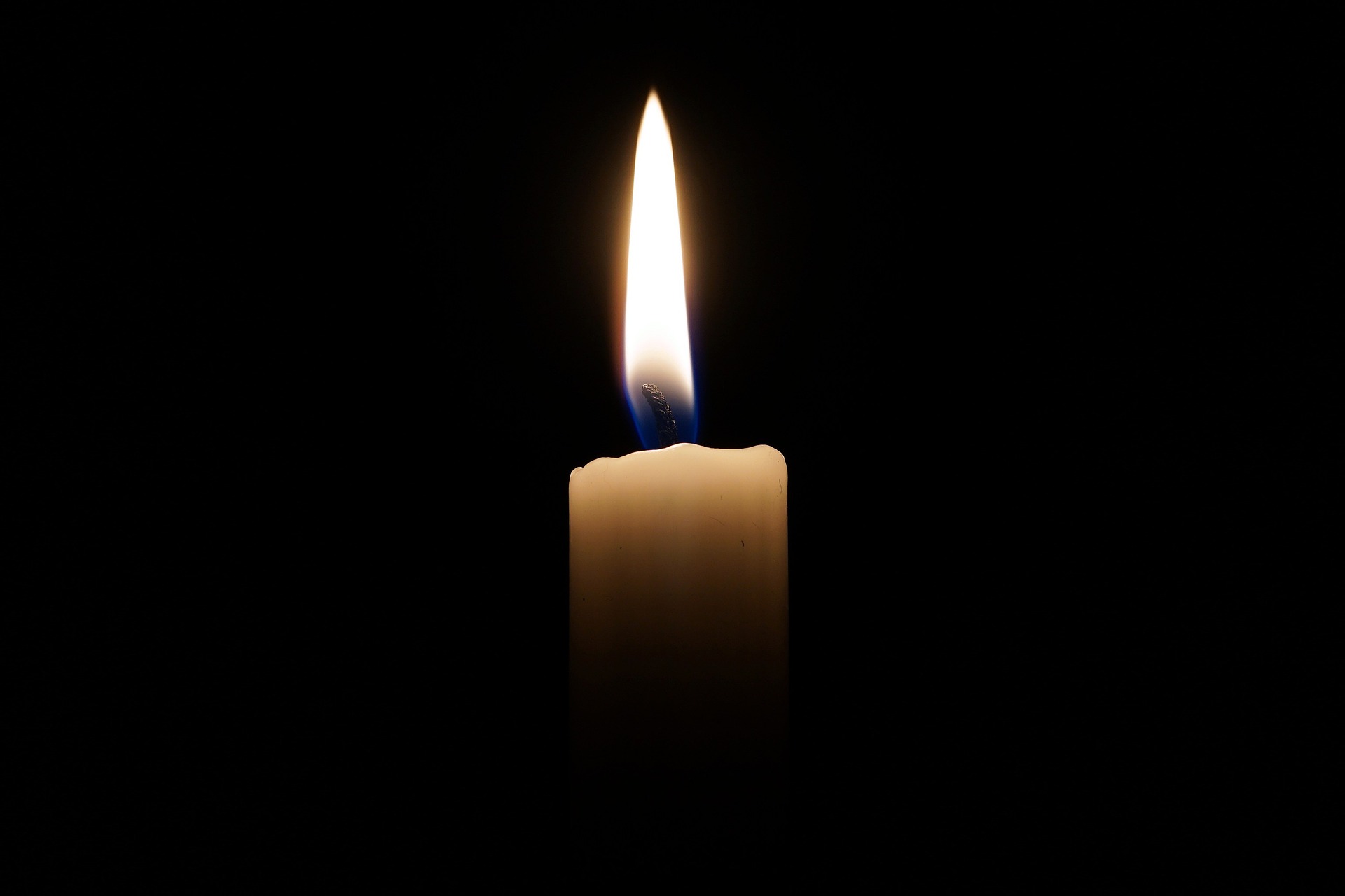 small candle burning in remembrance of deceased loved one